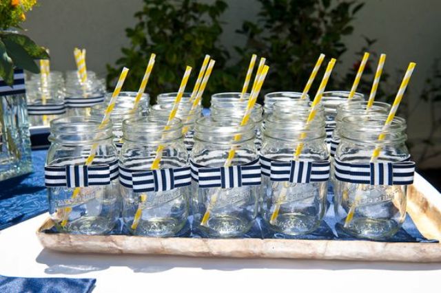 mason jars with striped bows and yellow straws are perfect for serving cocktails at the party
