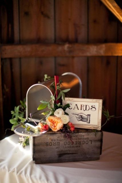 a rough wooden box with a frame and a mailbox where the guests will leave their cards for the couple