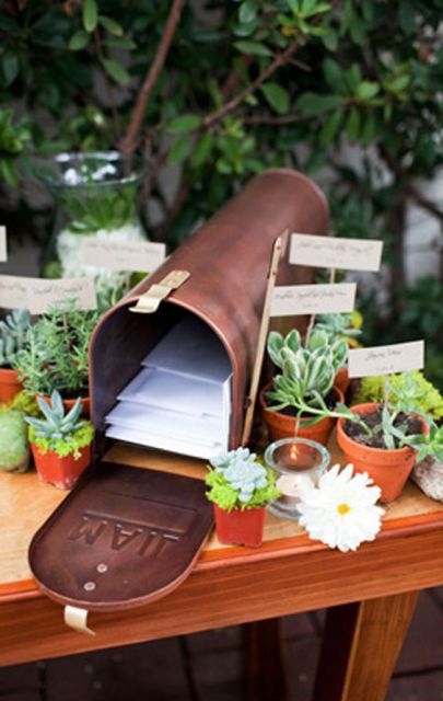 a stylish metal mailbox with letters from your guests inside, place potted succulents that are favors around