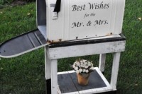 a large vintage mailbox on a matching white wooden stand to gather the wishes to the couple