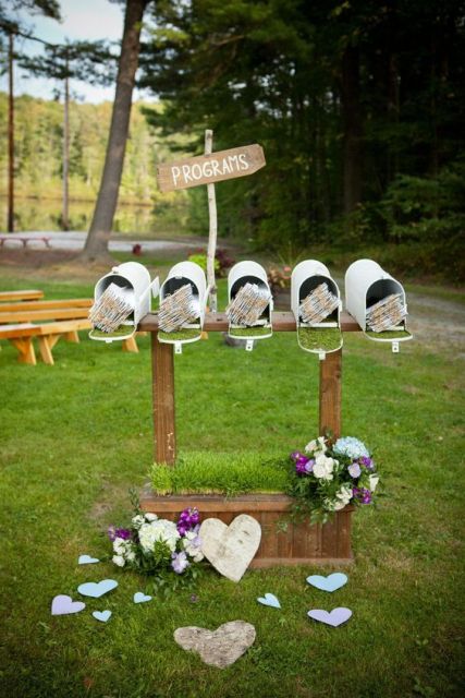 a row of white mailboxes used to display programs of the wedding is a cool and creative idea