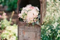 a rust metal mailbox filled with pastel blooms as a pretty and simple wedding decoration