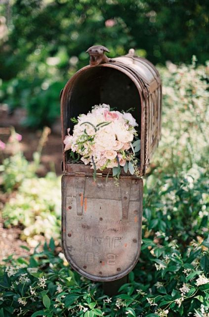 a rust metal mailbox filled with pastel blooms as a pretty and simple wedding decoration