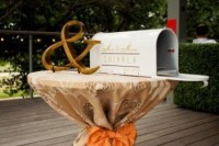 a mini table with a mailbox decorated with monograms and ampersand to leave wishes to the couple
