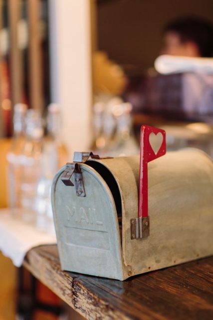 a small farmhouse inspired mailbox, which is whitewashed and with a little heart mark for a rustic wedding