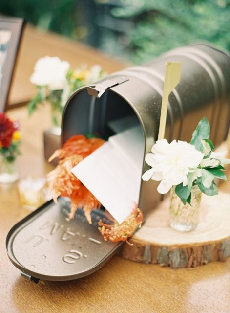a simple metal mailbox with bright blooms and wishes from the guests to the couple