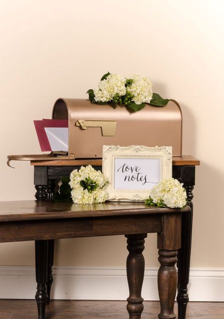 a chic copper mailbox with fresh hydrangeas and greenery on it plus a frame with your names for leaving wishes