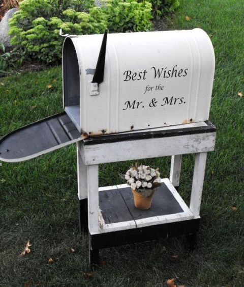 a large vintage mailbox on a matching white wooden stand to gather the wishes to the couple
