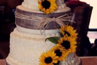 a rustic wedding cake decorated with burlap, yarn and sunflowers for a stylish and simple look