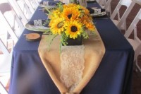 bright sunflower wedding centerpieces with some greenery and a burlap runner for a cozy rustic look