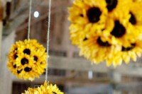 sunflower pompoms hanging over the reception or your wedding arch for a bright rustic look