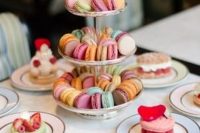 a beautiful and cute Parisian themed bridal shower sweets table with lots of colorful macarons and other desserts