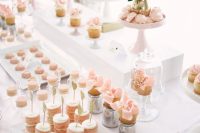 a beautiful blush Parisian-style sweets table with lots of delicious desserts, pink meringues and a pink cake, with blush blooms