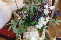 a beautiful brass teapot with bright blooms, greenery and vintage books plus lace