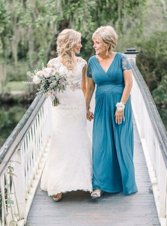 a blue maxi dress with a draped bodice and waist, a deep V-neckline and lace sleeves plus silver shoes