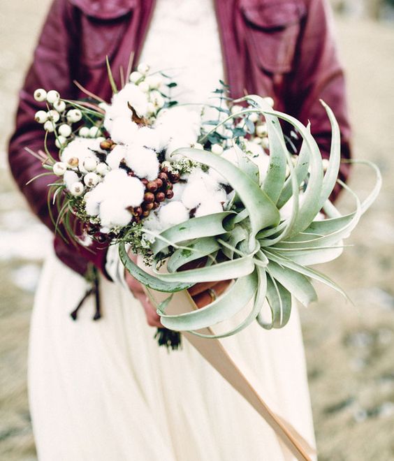 a boho wedding bouquet of an air plant, cotton, berries and greenery is a stylish idea with much texture and interest