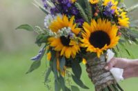 a bold wedding bouquet made of sunflowers, purple and white blooms and much greenery and wheat