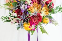 a bold wedding bouquet with yellow, burgundy, purple blooms including dahlias, greenery, astilbe and purple ribbons is fun