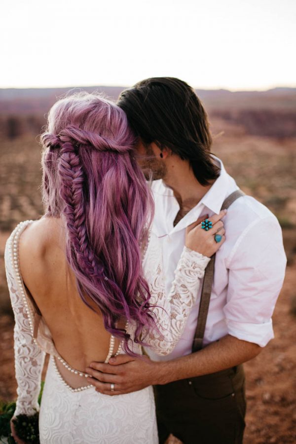 a bride wearing a refined lace sheath wedding dress with pearls, purple waves down with a twisted halo and a braid is wow