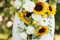 a cascading wedding bouquet of sunflowers, white blooms and some greenery for a summer bride