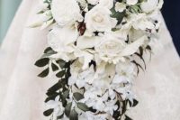 a cascading wedding bouquet with peonies, small and large roses and foliage looks refined and luxurious