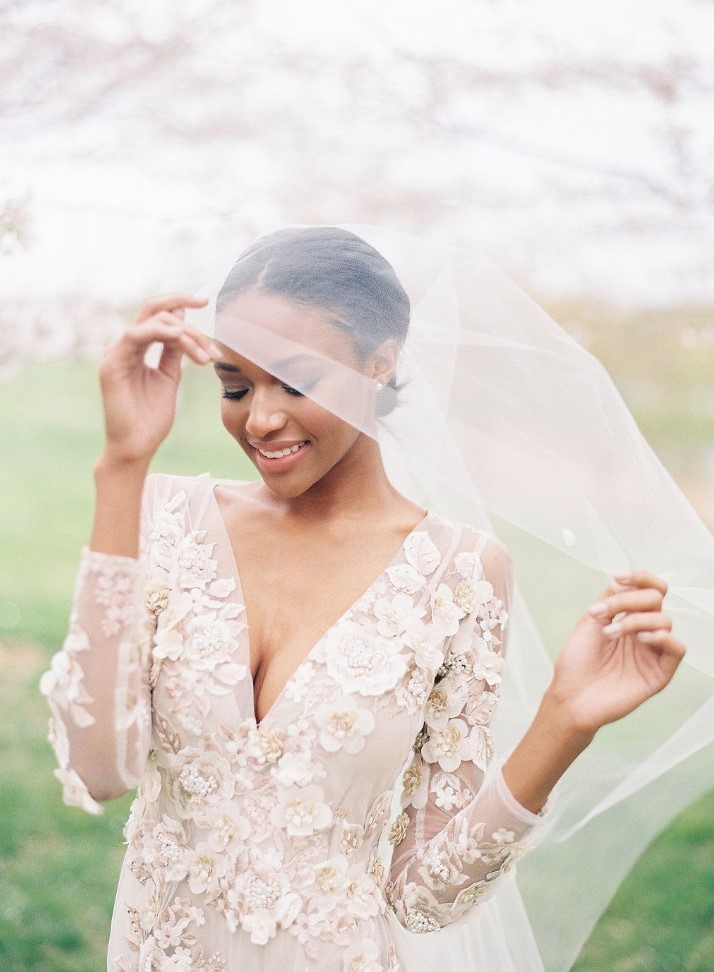 a chic blush wedding dress with cherry blossom applique, a deep V-neckline and long sleeves plus a delicate veil for a subtle spring bridal look