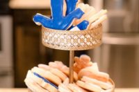 a chic stand with anchor shaped cookies in blue and white is a cool dessert idea for a nautical bridal shower