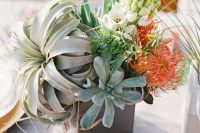 a chic wedding centerpiece with orange and white blooms, succulents and an air plant in a box is a lovely and bold idea