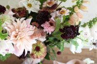a contrasting wedding bouquet of blush dahlias, deep purple and white blooms, some bold fillers and greenery and ribbon