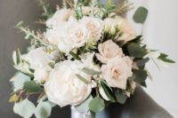 a cool white wedding bouquet of peonies and roses, some herbs and greneery plus a white ribbon
