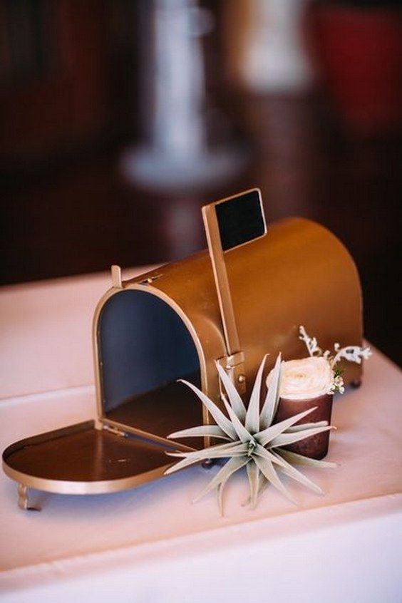 a copper mailbox with a flag and an air plant plus some blooms for a modern wedding