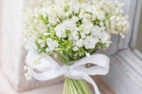 a cute white wedding bouquet of lily of the valley and some other blooms plus a bow for a casual bride
