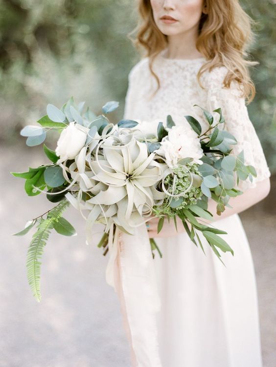 a delicate neutral wedding bouquet of white blooms, greenery and an air plant is a lovely idea for a spring or summer wedding