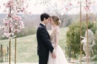 a delicate wedding arch with a bit of pink cherry blossom is a gorgeous idea for a subtle spring wedding