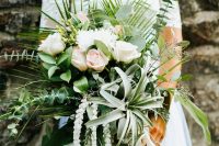 a dimensional and textural wedding bouquet of white and blush blooms, greenery, an air plant and some foliage for a unique look