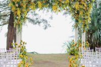 a fall wedding ceremony space done with textural greenery, sunflowers and sunflowers lining up the aisle