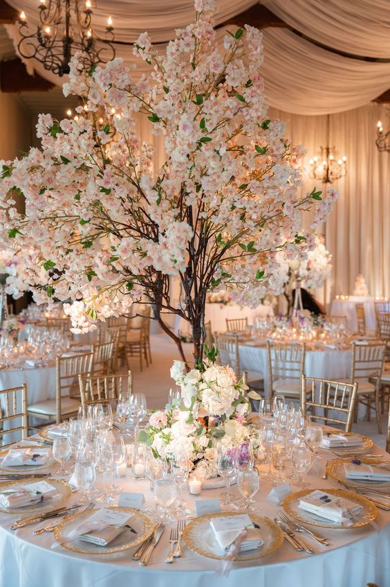 a formal wedding reception with faux blooming cherry trees, blooms on the table and candles around for a spring wedding