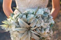 a glam beach wedding bouquet of white blooms, pale greenery and an air plant is a stylish idea for a beach wedding