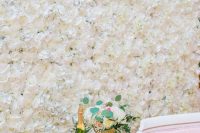 a gorgeous white flower wall, elegant and refined pink furniture, neutral blooms and gold calligraphy for a Parisian bridal shower