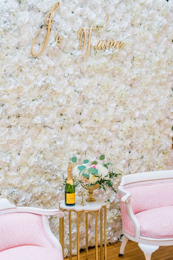 a gorgeous white flower wall, elegant and refined pink furniture, neutral blooms and gold calligraphy for a Parisian bridal shower