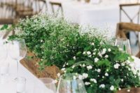 a long rustic planter with several types of white flowers and greenery will refresh your wedding reception