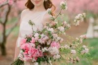 a long stemmed wedding bouquet with hot pink peonies, pink cherry blossom and striped ribbons is amazing for a spring bride