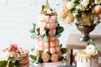 a lovely blush sweets table with a waffle cake, a macaron tower, a mini cake and some blooms is a pretty solution for a Parisian-themed bridal shower
