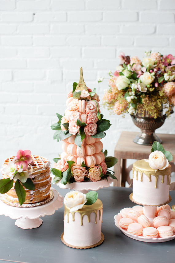 a lovely blush sweets table with a waffle cake, a macaron tower, a mini cake and some blooms is a pretty solution for a Parisian themed bridal shower