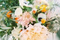 a lovely wedding bouquet of blush dahlias, white anemones and yellow ranunculus, greenery and astilbe is wow