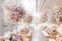 a lovely wedding reception space wiht lush cherry blossom wedding centerpieces and light pink napkins is amazing