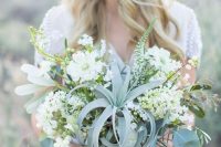 a lush neutral wedding bouquet of white blooms, greenery and an air plant plus lots of ribbons is a cool idea