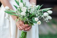 a minimalist bridal bouquet with white tulips, baby’s breath, thistles and leaves for a modern bride