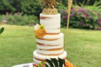 a naked tropical bridal shower cake decorated with a piece of pineapple, some bright tropical blooms and a monstera leaf