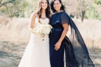 a navy maxi dress with a fitting silhouette, a sash and a sheer shawl on top are an amazing outfit for a formal wedding